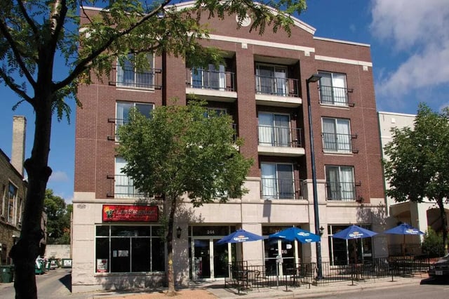 Brick building with balconies and umbrellas exterior at 625 on Langdon in Madison Student Accommodation