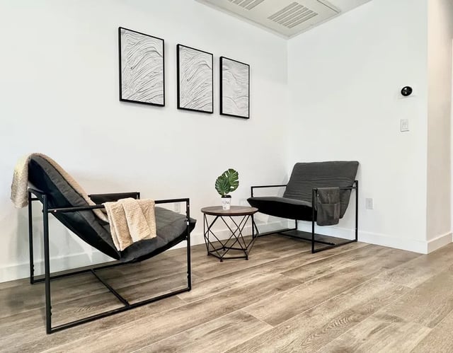 Two chairs artwork table plant living room at 1587 W 35th St in Los Angeles Student Accommodation