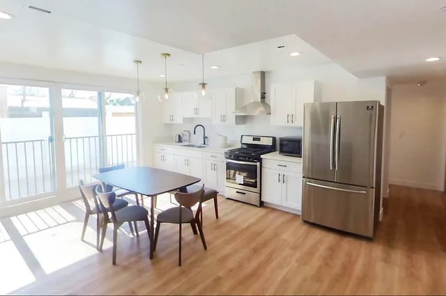 Dining table chairs stainless steel refrigerator kitchen at 1587 W 35th St in Los Angeles Student Accommodation