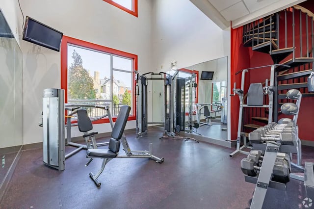 Gym equipment, bench, weights, spiral stairs Fitness room at 65 West in Cincinnati Student Accommodation