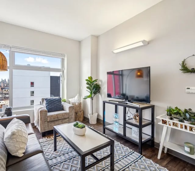 Sofa armchair coffee table and tv living room at The View at Montgomery in Philadelphia Student Accommodation