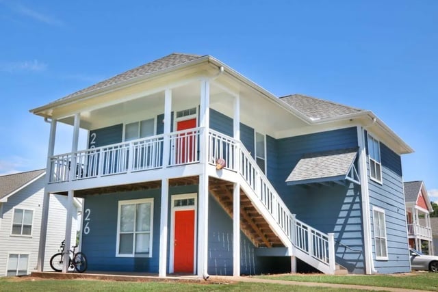 Blue building with red doors and stairs exterior at Clemson Village in Clemson Student Accommodation