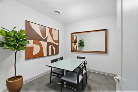 Table with chairs abstract art and plant living room at Polk On Third - Off Campus Student Housing in Bethlehem Student Accommodation