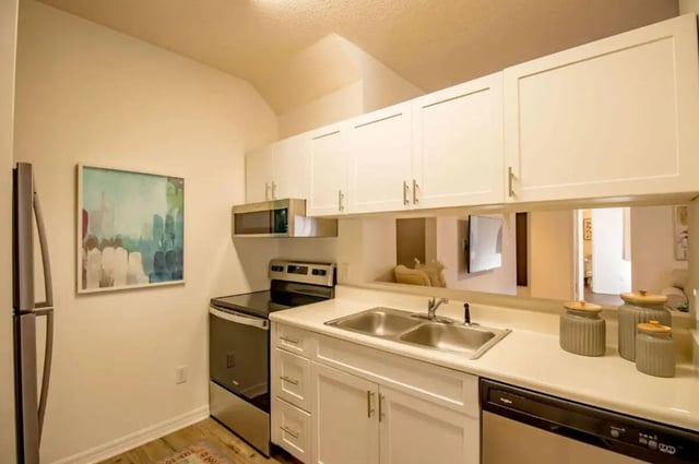Modern kitchen with stainless steel appliances and white cabinets kitchen at The French Quarter Apartments in Auburn Student Accommodation