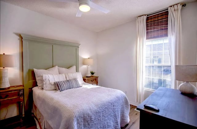 Bed with headboard bedside lamps and dresser Bedroom at The French Quarter Apartments in Auburn Student Accommodation