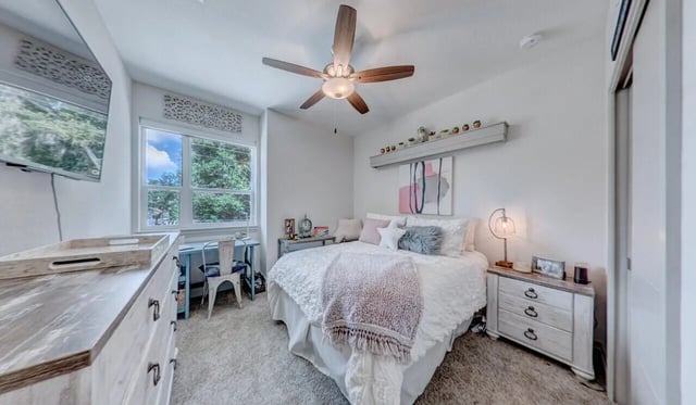 Bed with white comforter and pink throw bedroom at Cascades Luxury Apartments in Gainesville Student Accommodation