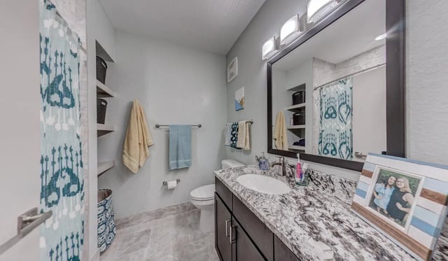 Toilet vanity mirror towels shower curtain bathroom at Cascades Luxury Apartments in Gainesville Student Accommodation