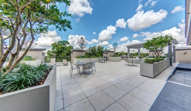 Outdoor patio seating with tables and chairs exterior at Cascades Luxury Apartments in Gainesville Student Accommodation