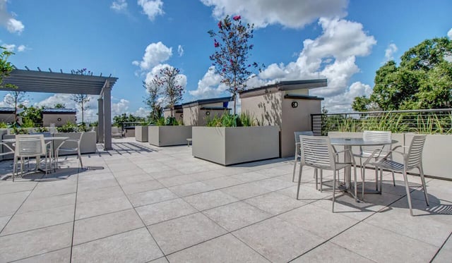 Tables and chairs on tiled patio exterior at Cascades Luxury Apartments in Gainesville Student Accommodation