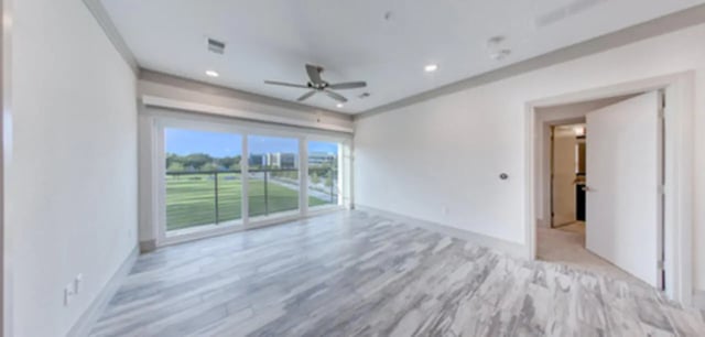 Empty room with large windows ceiling fan and open door Living room at Cascades Luxury Apartments in Gainesville Student Accommodation