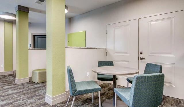 Table and chairs with white double doors lounge area at Cascades Luxury Apartments in Gainesville Student Accommodation