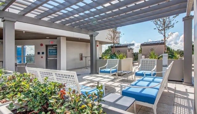 Outdoor seating lounge with pergolas and plants patio at Cascades Luxury Apartments in Gainesville Student Accommodation