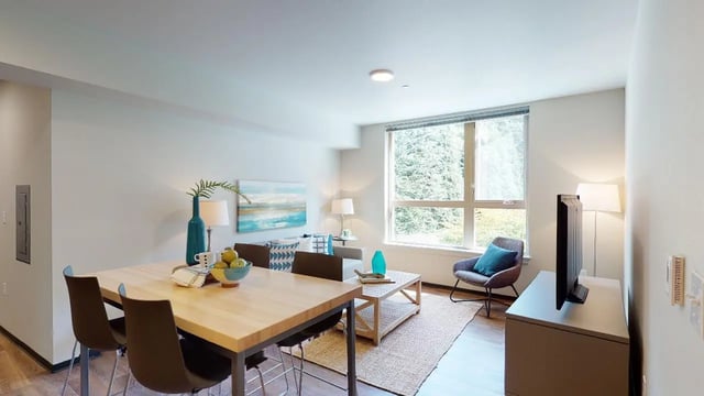 Dining table chairs sofa and television living room at 7000 Campus Living Apartments in Shoreline Student Accommodation
