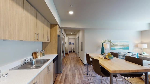 Kitchen dining table with fruit and chairs living room at 7000 Campus Living Apartments in Shoreline Student Accommodation