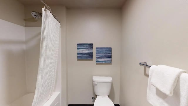 Shower tub toilet towel rack artwork bathroom at 7000 Campus Living Apartments in Shoreline Student Accommodation