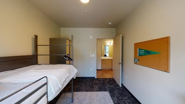 Bed with metal frame and closet visible bedroom at 7000 Campus Living Apartments in Shoreline Student Accommodation