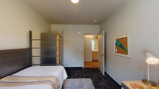 Bed metal shelves dresser and corkboard bedroom at 7000 Campus Living Apartments in Shoreline Student Accommodation