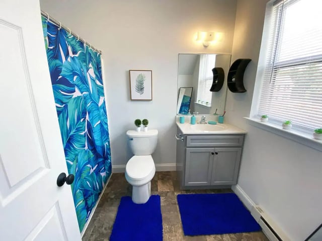 Toilet vanity sink shower curtain and mat bathroom at The Rail Yard in Newark Student Accommodation