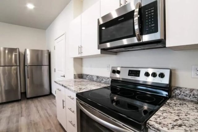 Two refrigerators microwave stove granite countertops kitchen at Sundance Apartments - BYU-Idaho Approved Housing in Rexburg Student Accommodation