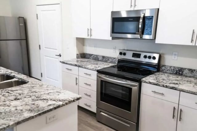 White cabinets stainless steel appliances kitchen at Sundance Apartments - BYU-Idaho Approved Housing in Rexburg Student Accommodation