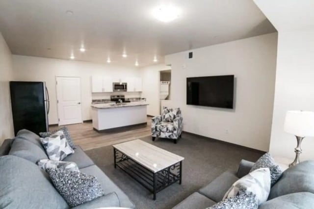 Sectional sofa, arm chair, kitchen, TV Living room at Sundance Apartments - BYU-Idaho Approved Housing in Rexburg Student Accommodation