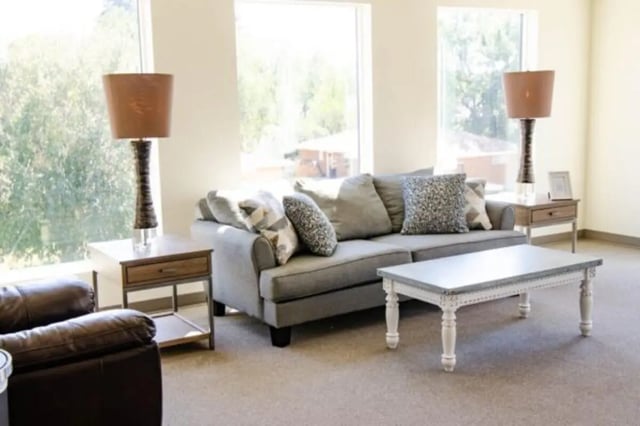 Gray sofa with patterned pillows coffee table living room at Sundance Apartments - BYU-Idaho Approved Housing in Rexburg Student Accommodation