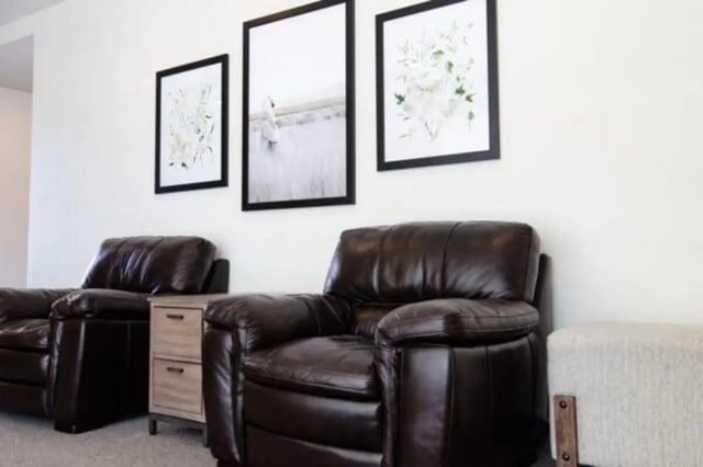 Leather chairs artwork and ottoman living room at Sundance Apartments - BYU-Idaho Approved Housing in Rexburg Student Accommodation