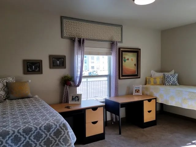 Two beds, desks, and butterfly art bedroom at The Towers Two - Women Approved Housing in Rexburg Student Accommodation