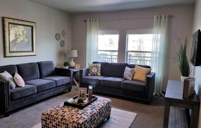 Two sofas ottoman wall art living room at The Towers Two - Women Approved Housing in Rexburg Student Accommodation