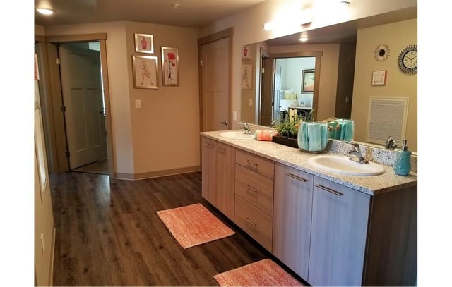 Double vanity sinks two rugs and wall art bathroom at The Towers Two - Women Approved Housing in Rexburg Student Accommodation