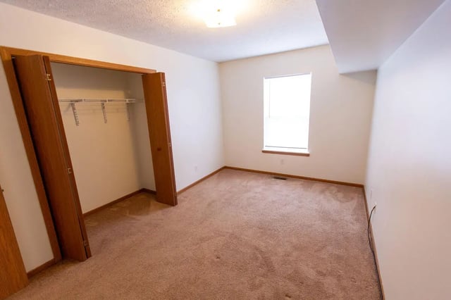 Closet with shelves window and carpeted floor bedroom at Copperfield Court in Morgantown Student Accommodation