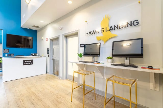 Computer stations with clear chairs reception area lounge at Hawks Landing in Oxford Student Accommodation