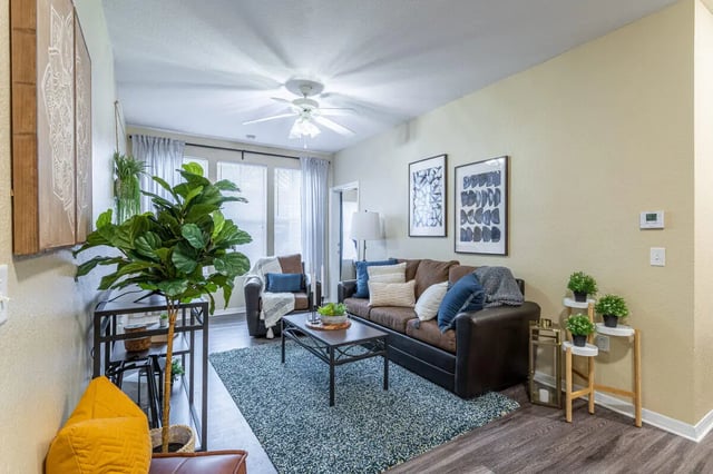 Brown sofa with pillows and blue rug living room at Hawks Landing in Oxford Student Accommodation