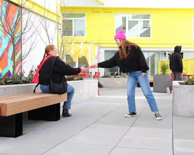Two students interacting on bench exterior at Blanton Turner in Seattle Student Accommodation