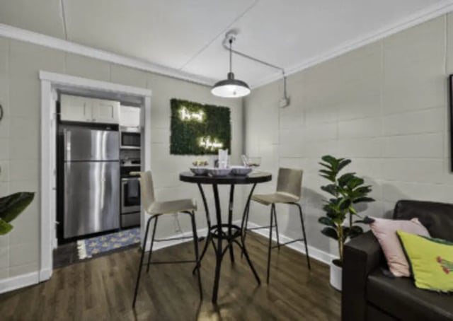 Table chairs refrigerator plants and couch living room at 759 Basin LLC in Tallahassee Student Accommodation