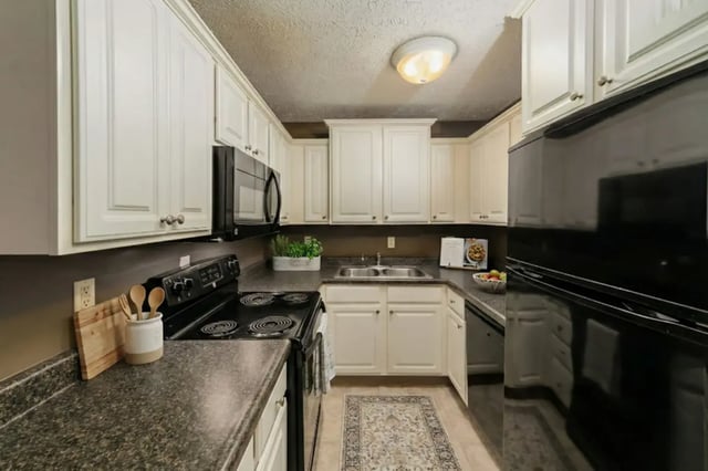 White cabinets microwave sink stove refrigerator kitchen at Waters Edge Apartments in East Lansing Student Accommodation