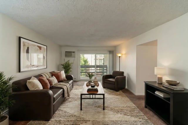 Leather sofa armchair rug artwork and table living room at Waters Edge Apartments in East Lansing Student Accommodation