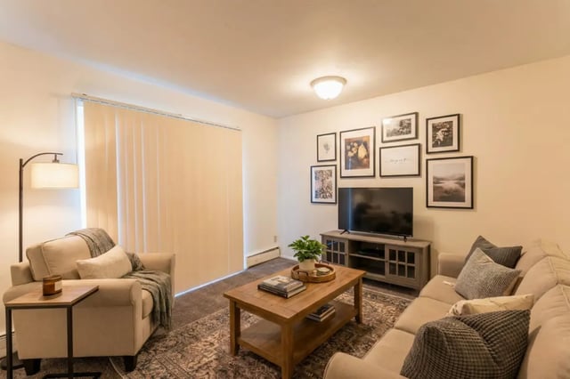 Sofa armchair coffee table television living room at Waters Edge Apartments in East Lansing Student Accommodation