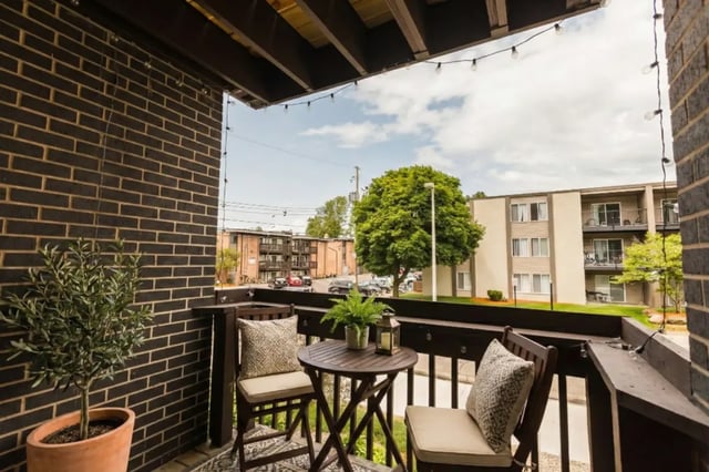 Two chairs table plant and fairy lights balcony exterior at Waters Edge Apartments in East Lansing Student Accommodation