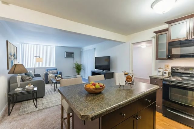 Kitchen with island living room and television at Waters Edge Apartments in East Lansing Student Accommodation