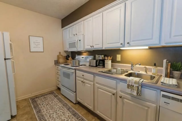 White cabinets refrigerator stove sink kitchen at Waters Edge Apartments in East Lansing Student Accommodation