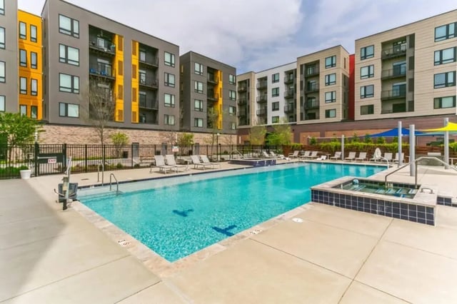 Apartment buildings surrounding a pool and hot tub exterior at Current Midtown Apartments in Williamsburg Student Accommodation