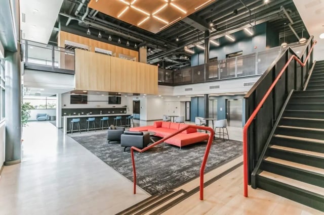 Modern lounge area with bar and stairs communal space at Current Midtown Apartments in Williamsburg Student Accommodation