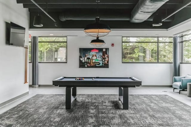 Pool table painting television and chairs recreation area at Current Midtown Apartments in Williamsburg Student Accommodation