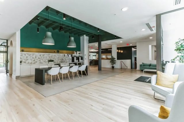 Table with chairs kitchen area and lounge area at Current Midtown Apartments in Williamsburg Student Accommodation