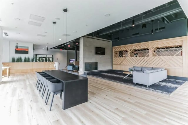 Communal table grey chairs sofa living room at Current Midtown Apartments in Williamsburg Student Accommodation