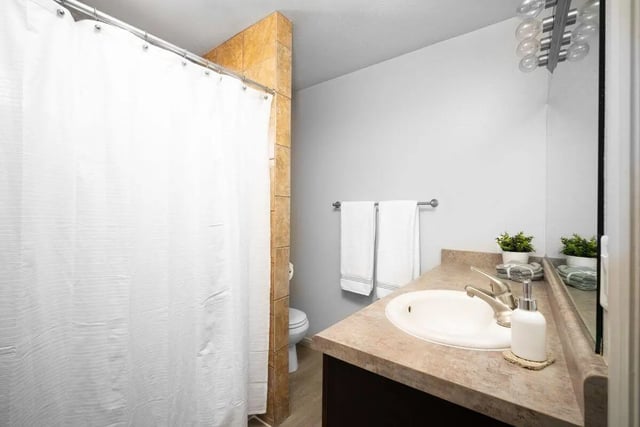 White shower curtain sink and towels bathroom at 7th & University Apartments in St. George Student Accommodation