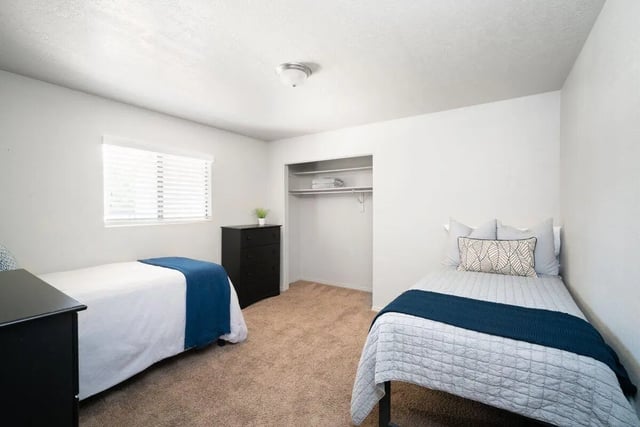 Two beds dresser window closet bedroom at 7th & University Apartments in St. George Student Accommodation