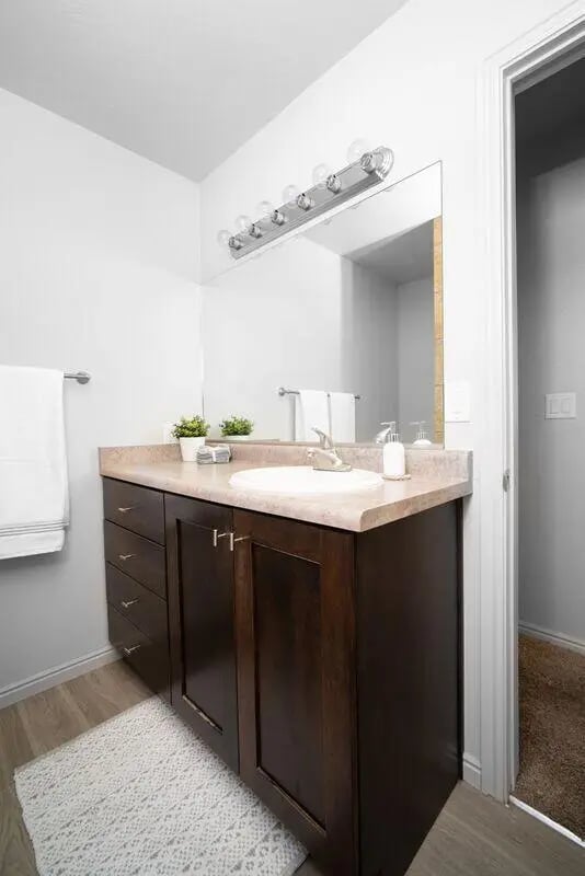 Sink vanity with cabinets towels and decor bathroom at 7th & University Apartments in St. George Student Accommodation