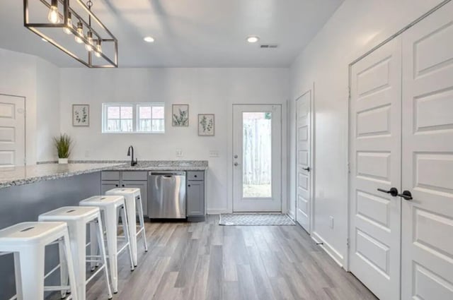 Four white stools at kitchen island and dishwasher kitchen interior at Haven Blacksburg in Blacksburg Student Accommodation